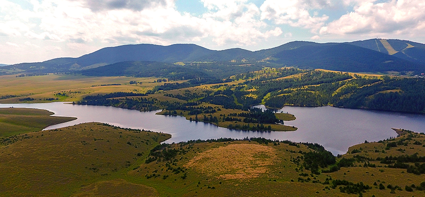 A few kilometers from the Zlatibor ,there is an artificial lake, called Ribničko Lake.It is the second largest on Zlatibor. 
The length of this lake is about 2000 meters. It is known for its very clear water, and the ground of the lake is covered with dark stones. 
Ribnica Lake is located near the ski center Tornik, so it is even more attractive. The lake was formed around 1970 by the dam of the river Crni Rzav. 
Because of that lake has a large dam in the middle. It is nice to walk by the lake and observe the natural views, because the lake is surrounded by a dense coniferous forest. 
Swimming in the lake is forbidden, but a large number of people cool off in the freshness of the water of Ribnica Lake in the summer.